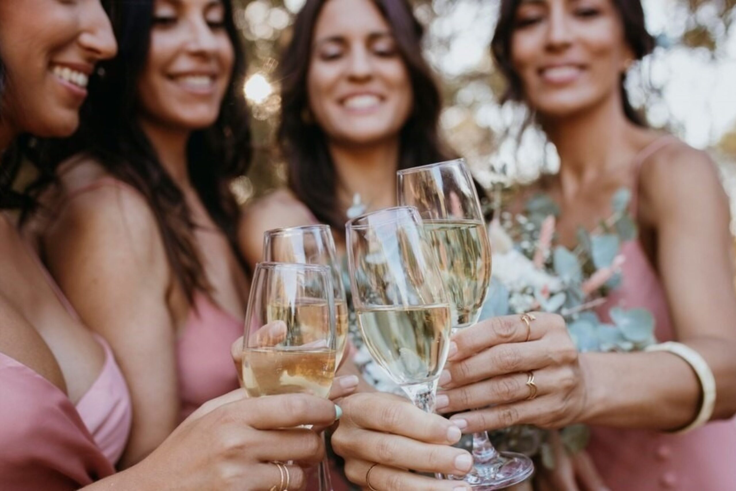 Elegant ladies toasting with glasses filled with golden grower champagne bubbles