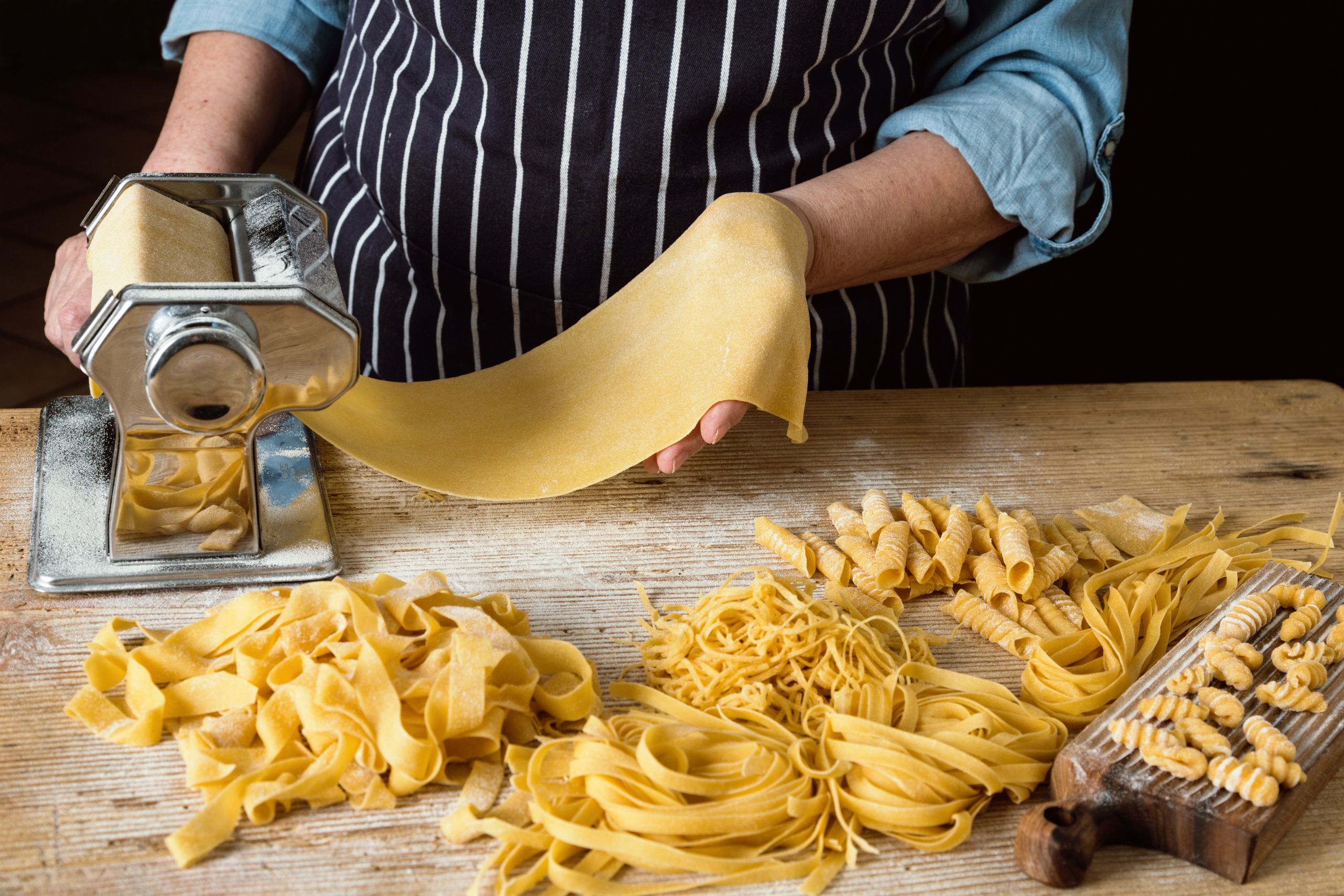 Fresh pasta nests dusted with semolina flour drying on a wooden surface before cooking