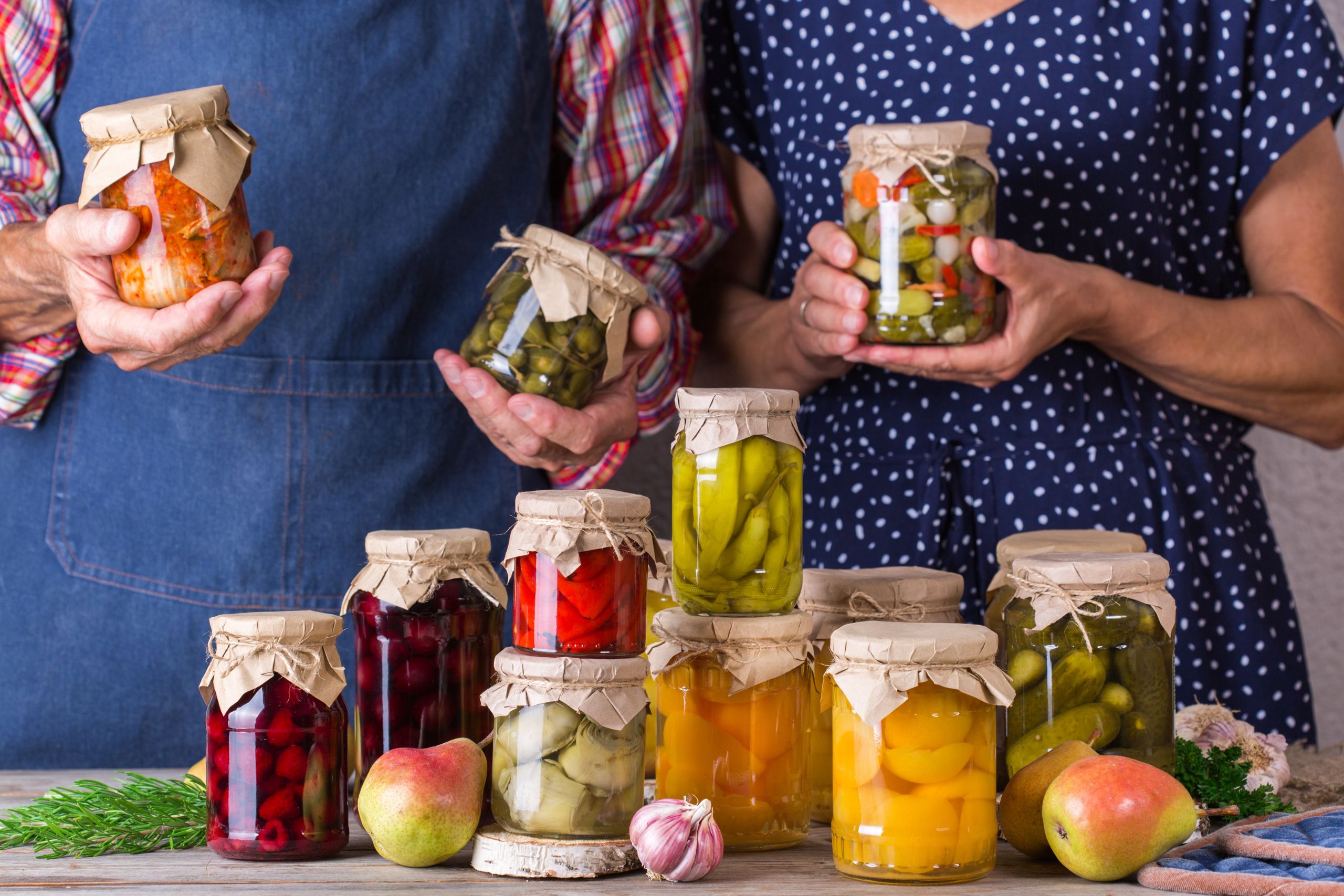 man and woman present fermented vegetables pots