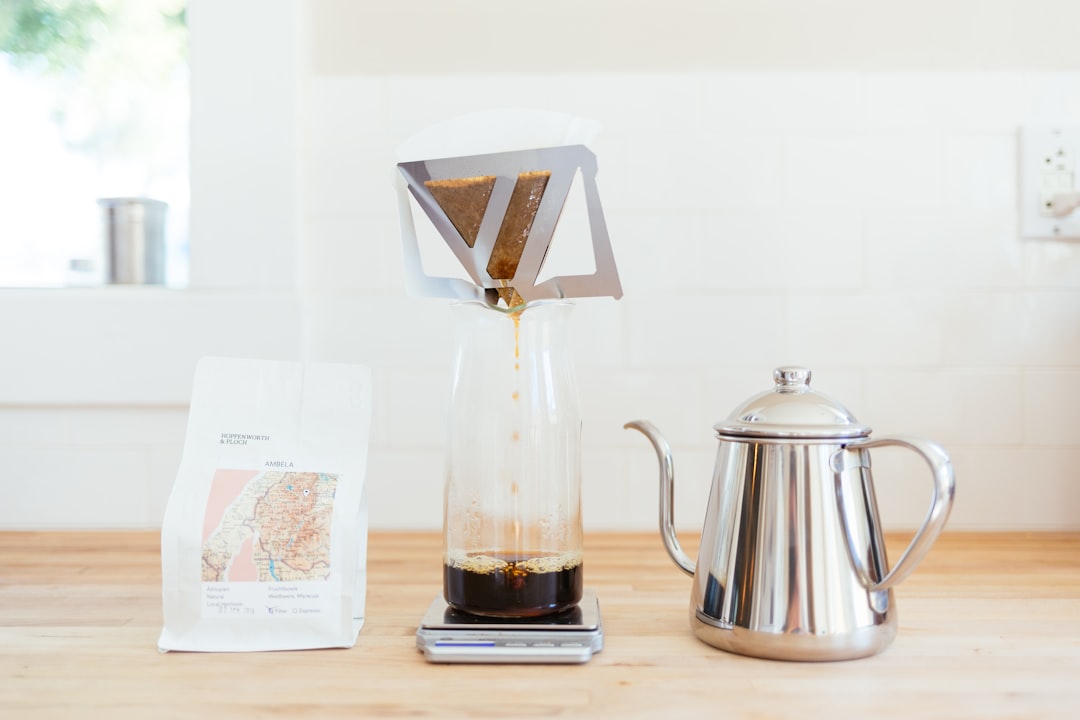 A barista carefully pouring hot water over single-origin coffee grounds in a pour-over dripper at a specialty café