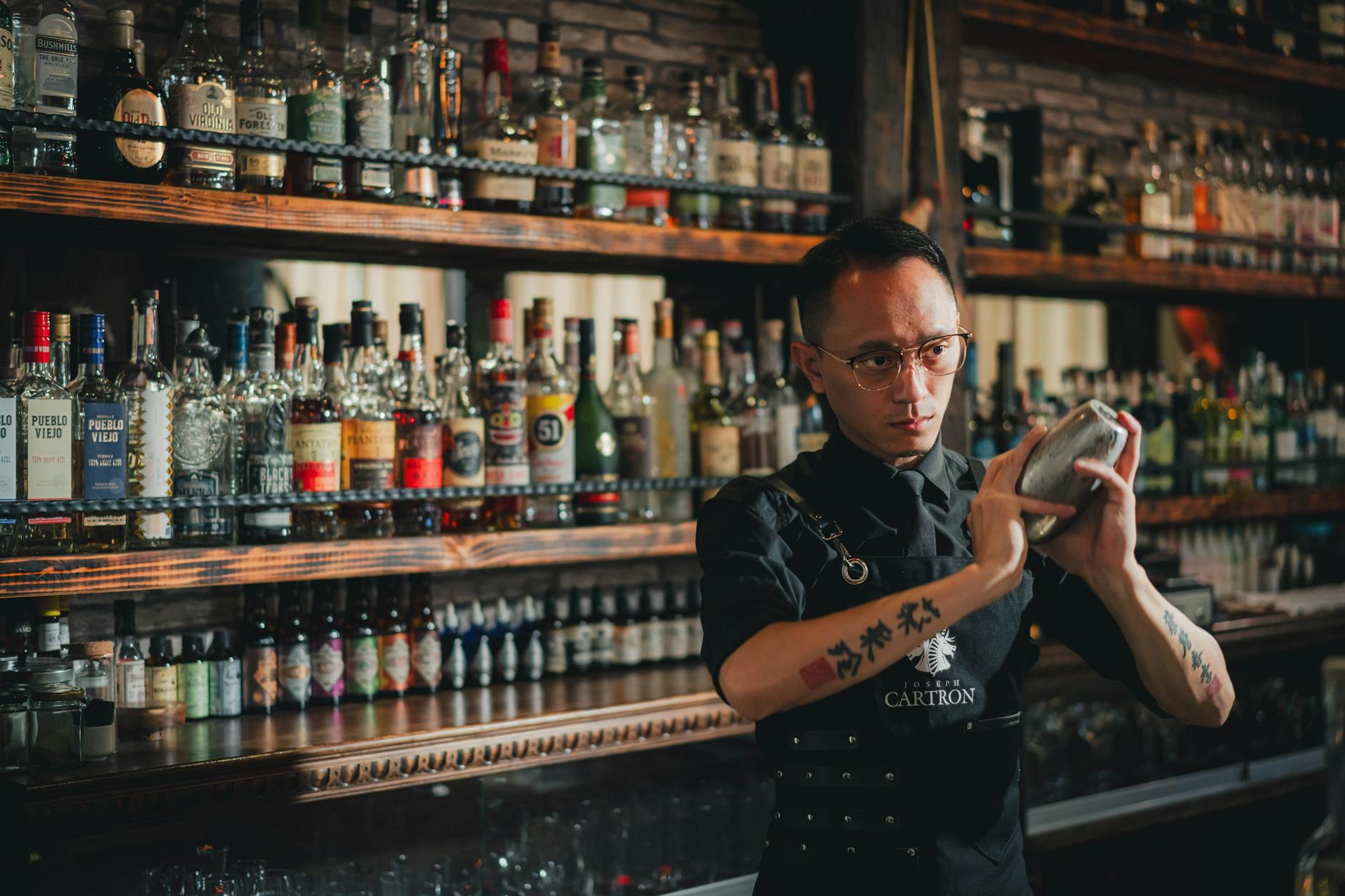 A skilled bartender demonstrating mixology training techniques while preparing a craft cocktail at a restaurant bar