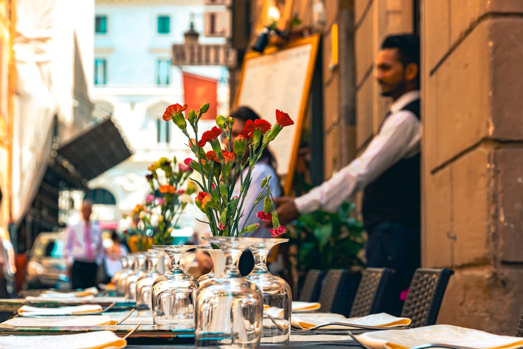 A chef sets a table on a restaurant patio preparing for summer patio service at the start of outdoor season.