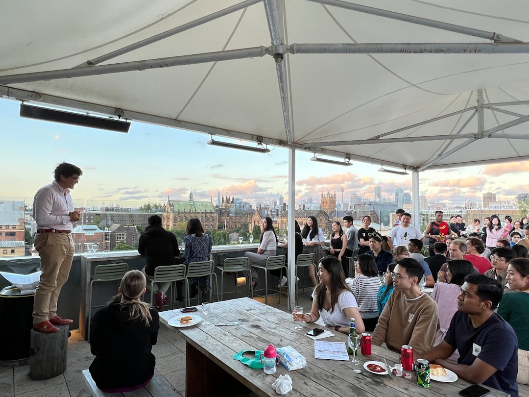 A chef carefully arranges light seasonal dishes on a rooftop dining terrace during a warm summer service
