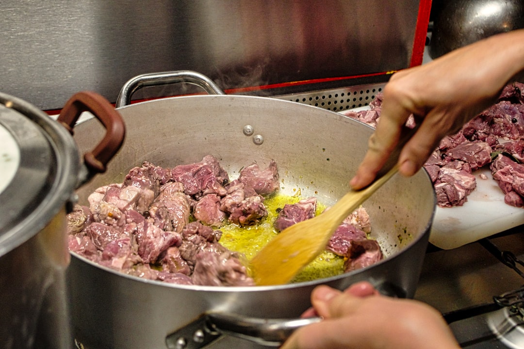 A chef carefully tending slow braises in a heavy cocotte, demonstrating classical technique over low heat