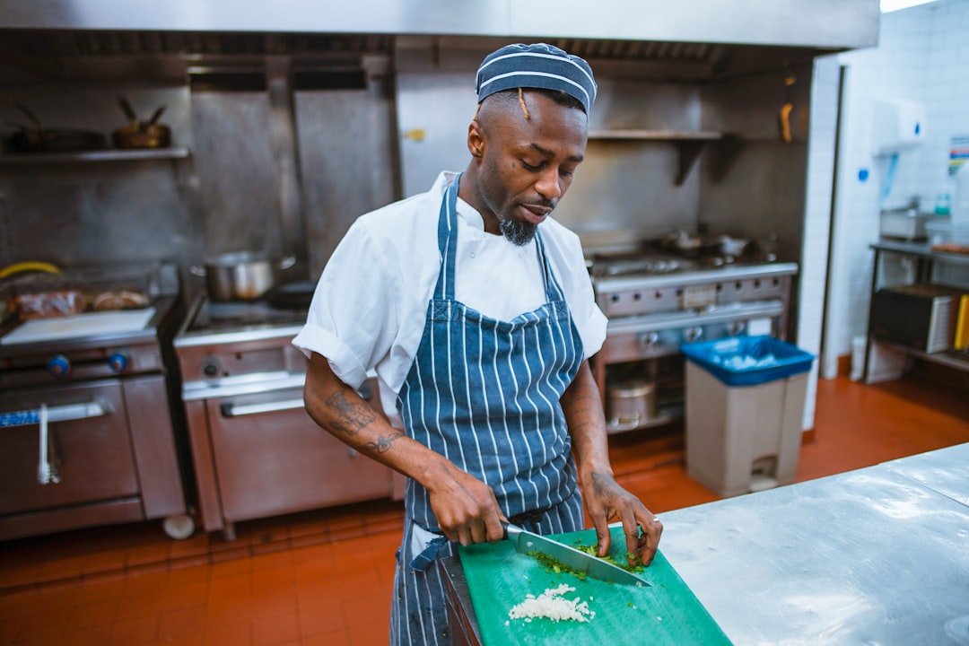 A chef plates a course during service, embodying the deliberate craft behind tasting menus that tell a seasonal story.