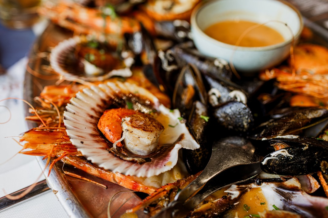 A chef carefully plates a fresh seafood dish as part of resort menus designed for peak coastal season guests