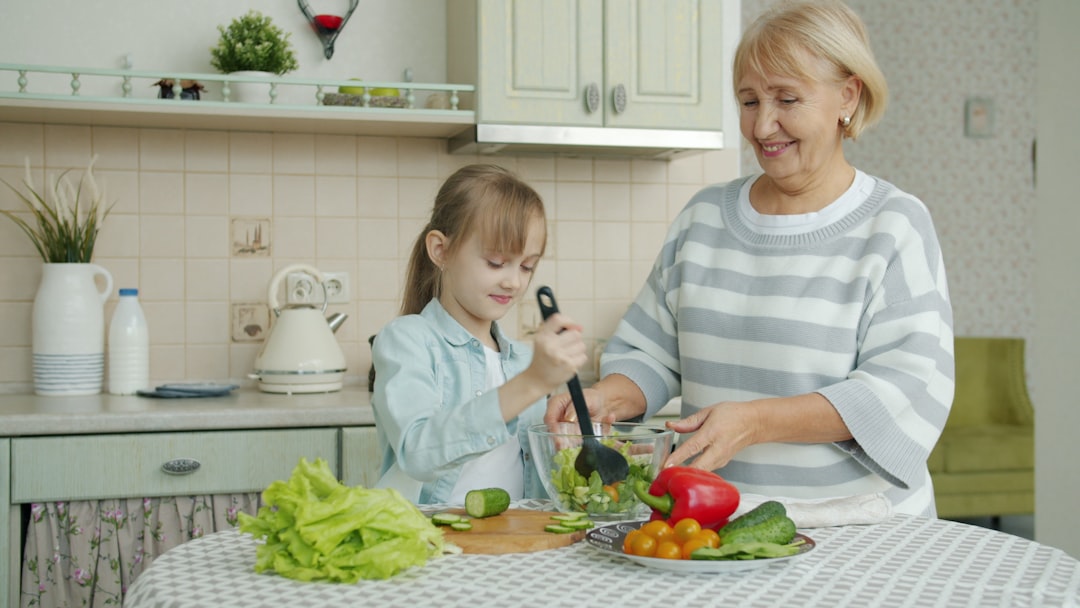A woman carefully dressing chilled grain salads in a bright kitchen, showcasing global culinary technique