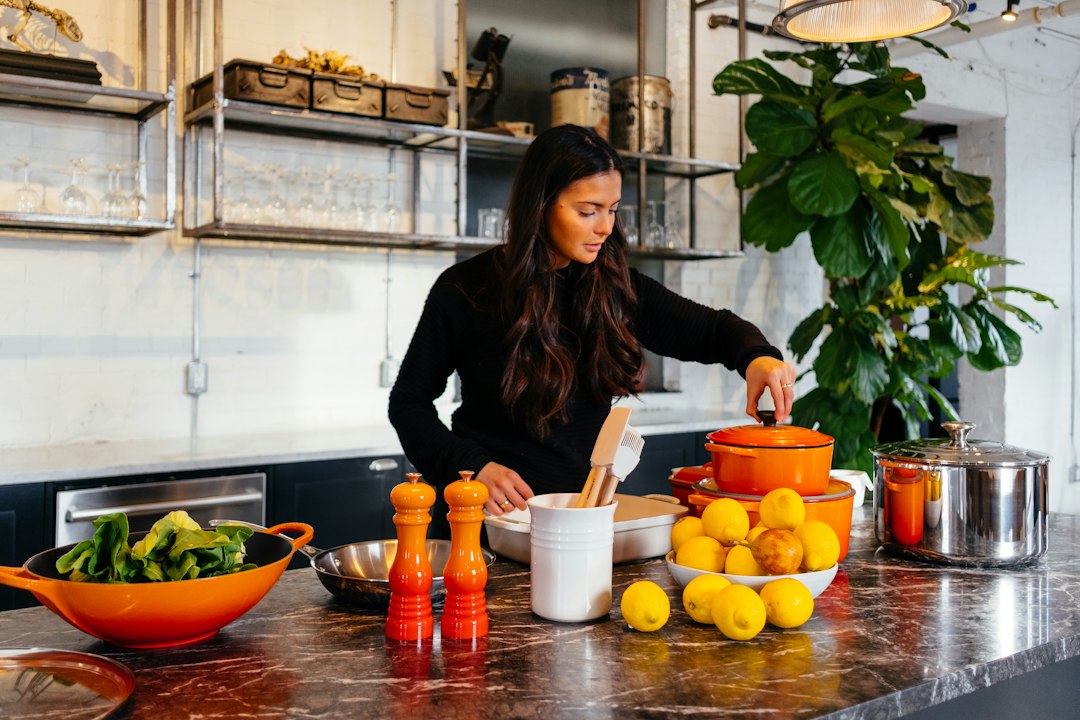 a woman arranges roasted root vegetables on a plate as part of the new autumn menus service in a kitchen.