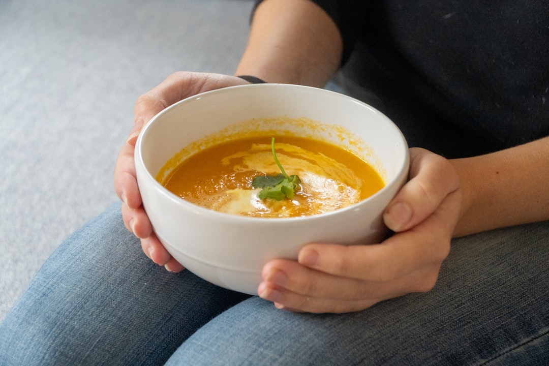 A chef carefully plates a bowl of autumn dishes in a professional kitchen, demonstrating classical harvest-season technique