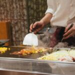 A chef roasting seasonal root vegetables in a professional kitchen at the autumn equinox, demonstrating classic techniques