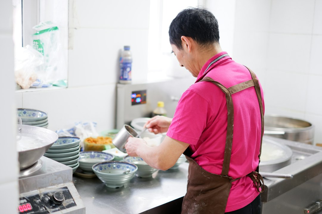 A chef carefully building an aromatic base in a pot, preparing a classic one-pot rice dish with layered spices and stock.